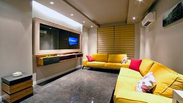 Executive Suite | Living area | 82-cm LCD TV with satellite channels, TV, books
