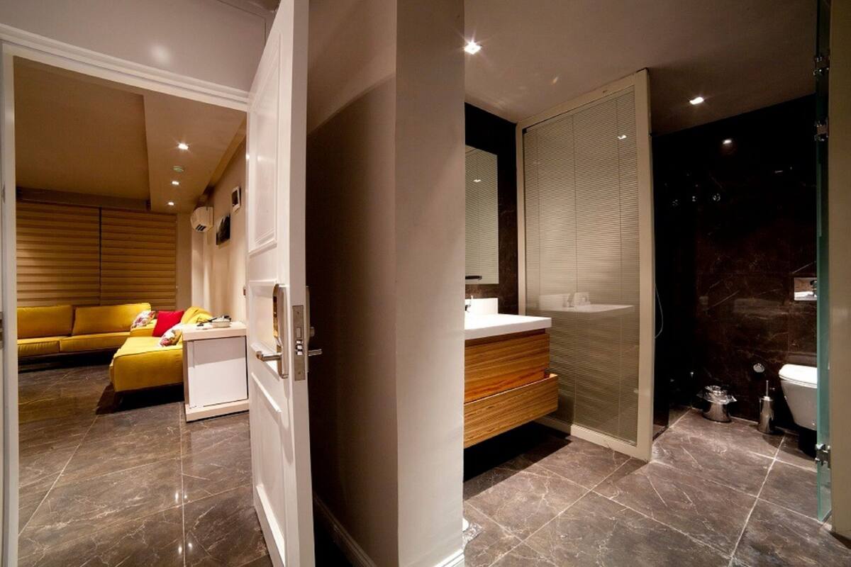 A modern bathroom with a glass shower enclosure, a white sink, and a toilet.