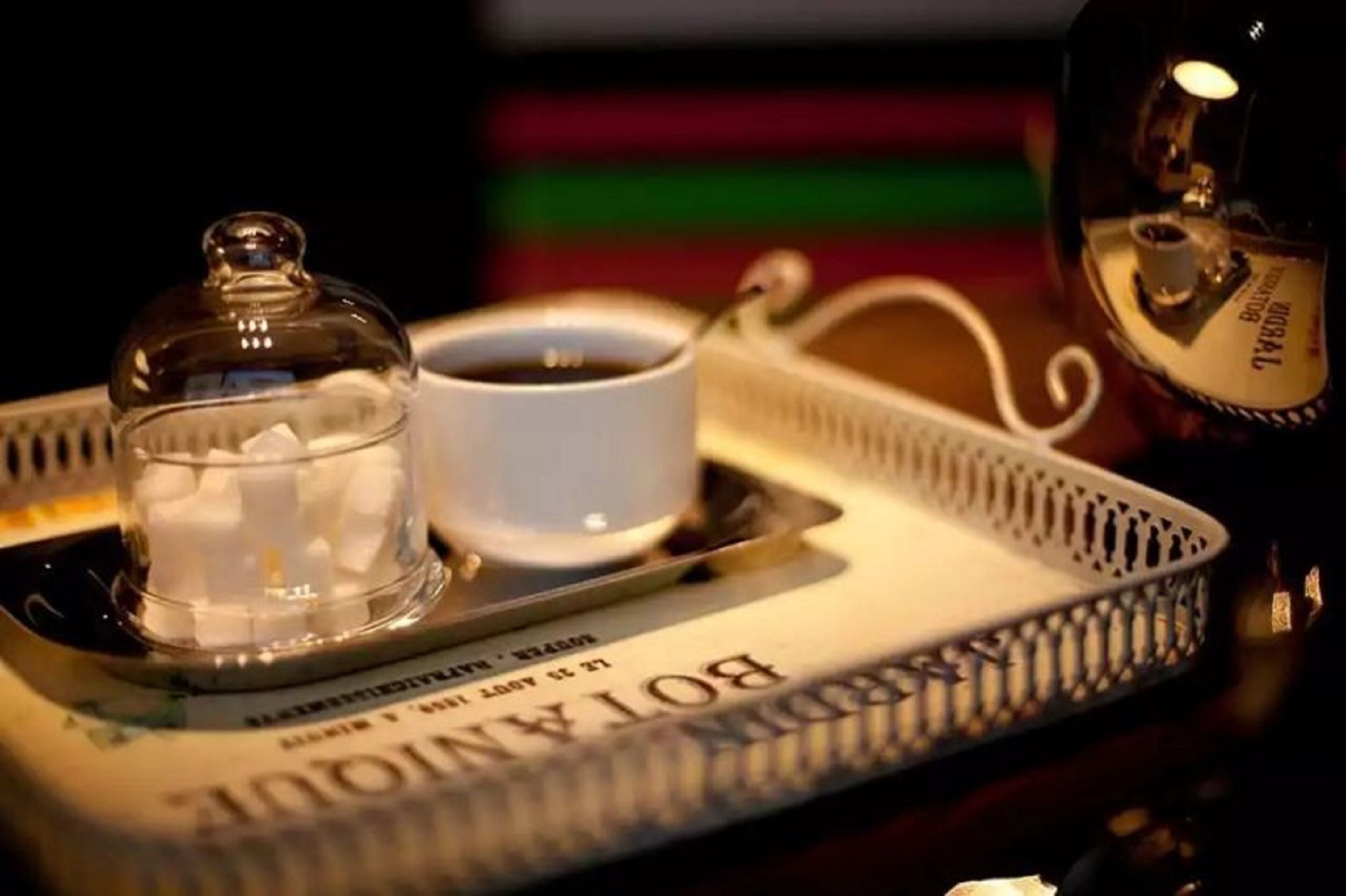 A tray with a cup of coffee, a sugar container, and a bottle of Brolin.