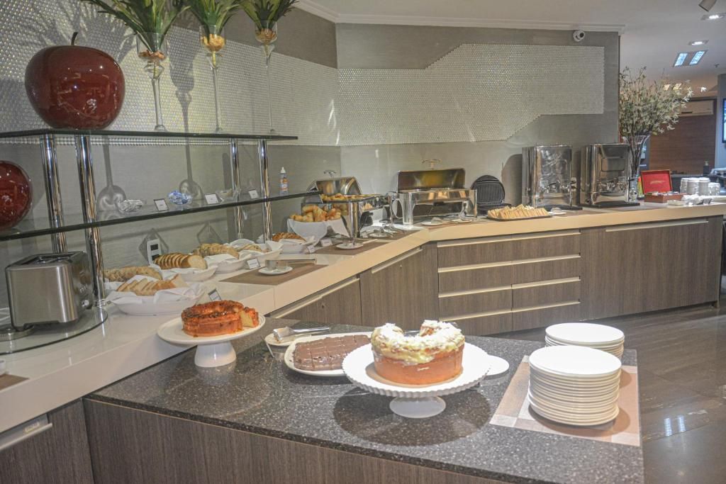 Un área de bufé con diferentes opciones de comida, una estación de café y una vitrina de vidrio con objetos decorativos.