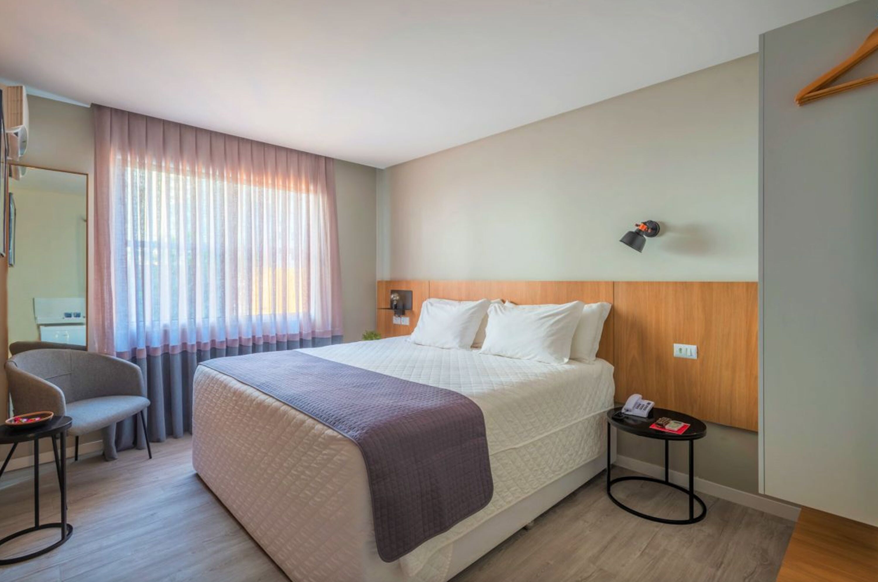 Une chambre d’hôtel avec un grand lit, un bureau et une chaise.