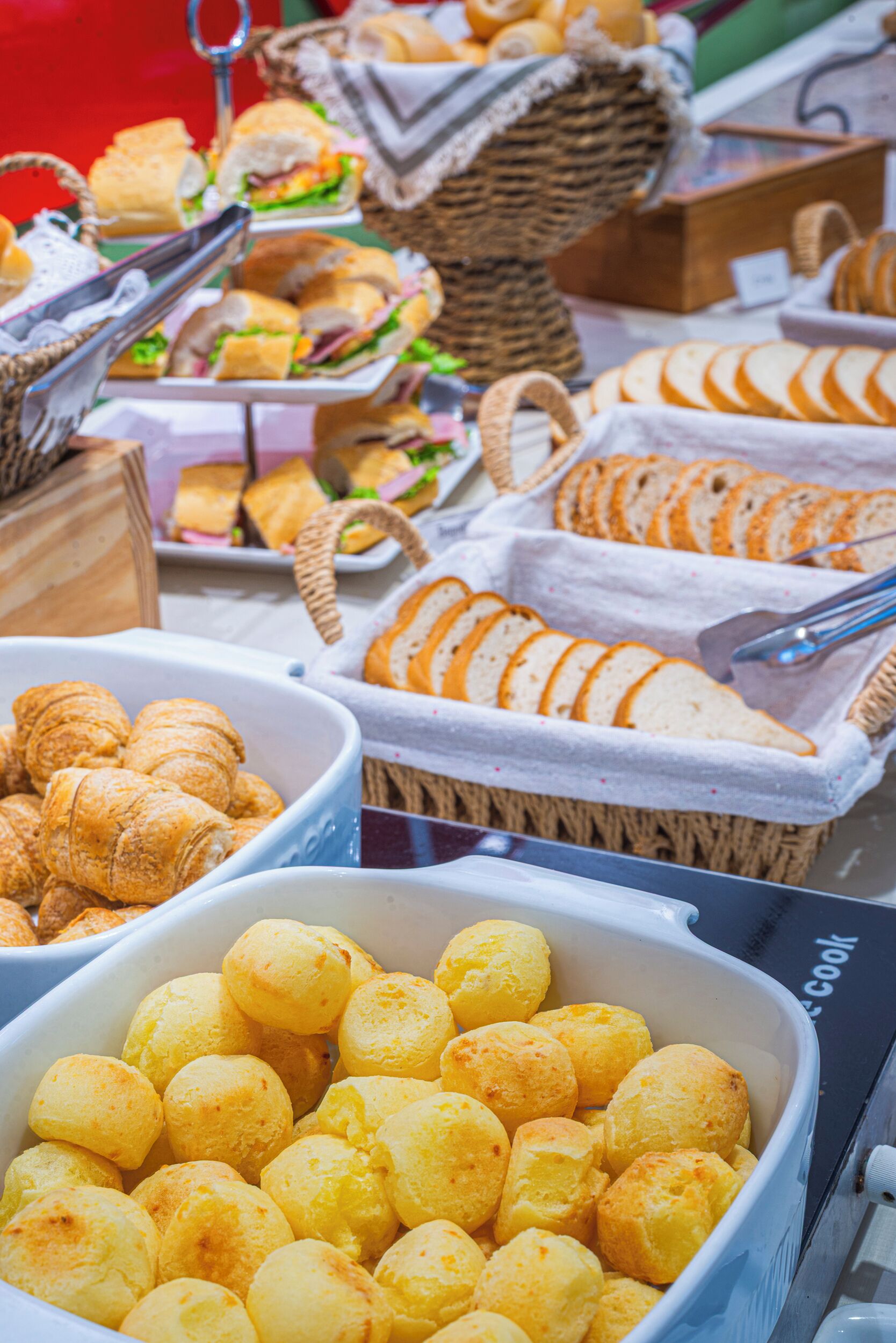 Un bufé con diferentes opciones de comida, como pan, croissants y queso.
