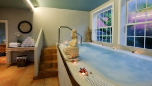 A spa area with a hot tub, a statue, and a window with a view of greenery. - Hotel Hacienda de Abajo - Adults Only (Tazacorte)