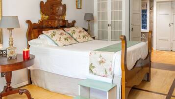 Un dormitorio con cama de madera, mesitas de noche y una silla verde.