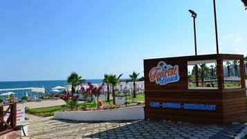Privéstrand vlakbij, ligstoelen aan het strand, parasols, een strandbar