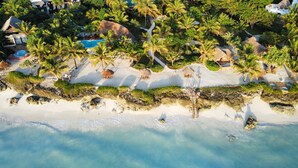 An aerial view of a tropical resort with a beach, palm trees, and a swimming pool. - The Zanzibari (Nungwi)