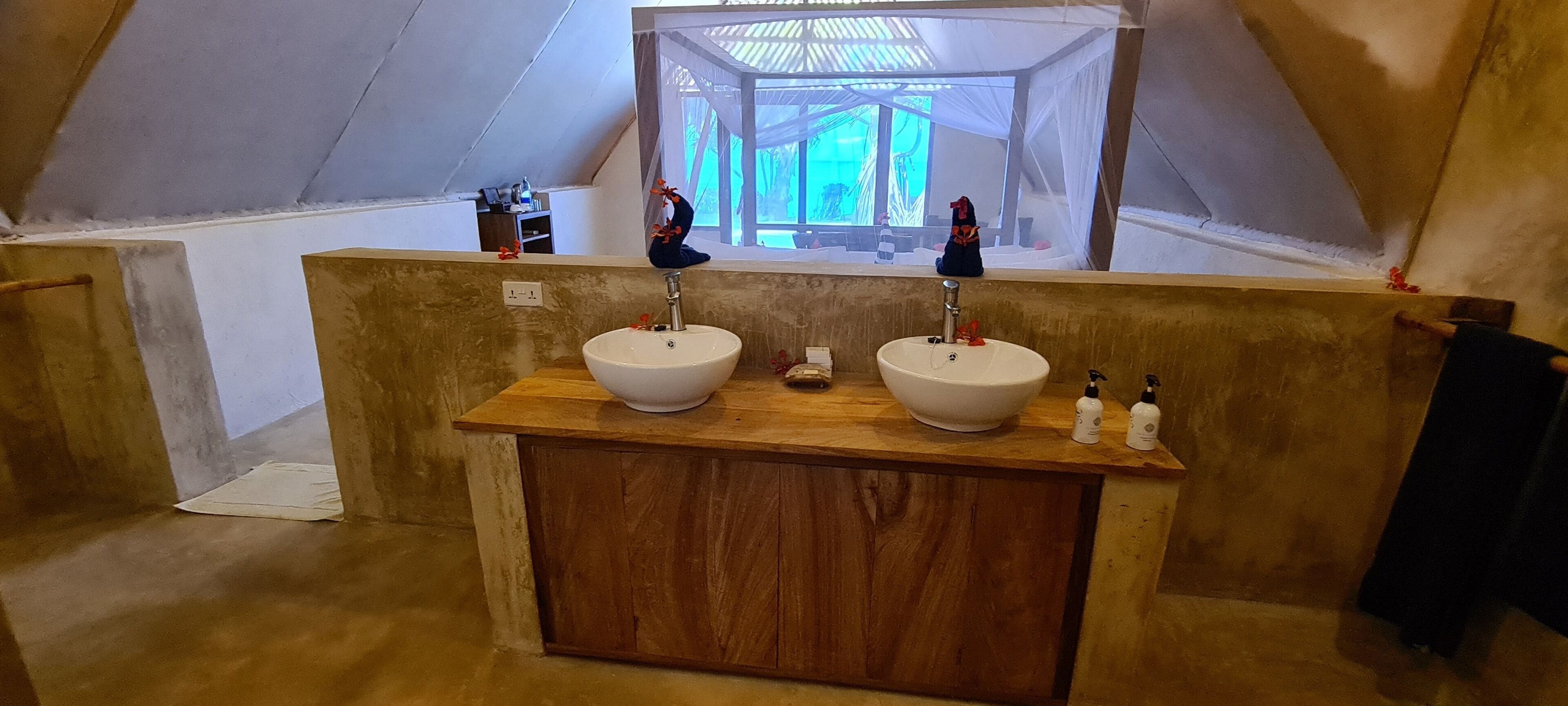 Een badkamer met twee wasbakken, een houten aanrechtblad en een grote spiegel.