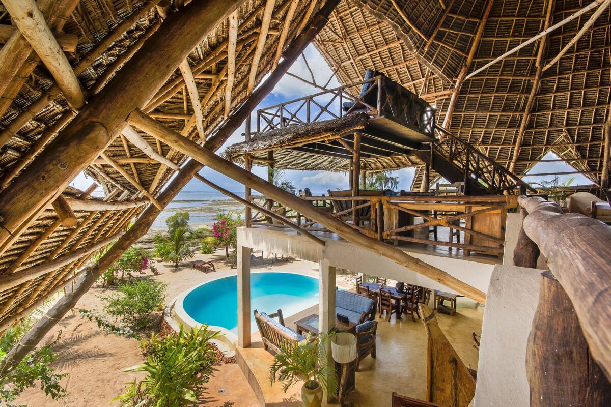 A wooden structure with a pool and outdoor seating.
