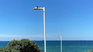 En la playa, arena blanca, sillas reclinables de playa, sombrillas