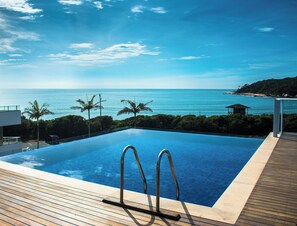 Una piscina con vista al océano y palmeras.