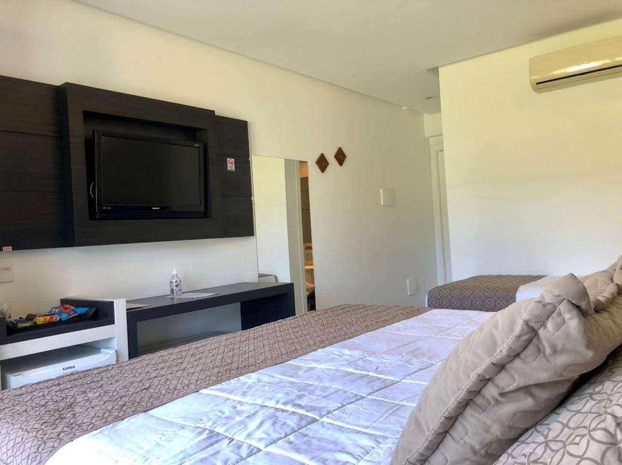 Ein Hotelzimmer mit einem Bett, einem Schreibtisch, einem Fernseher und einem Kleiderschrank.