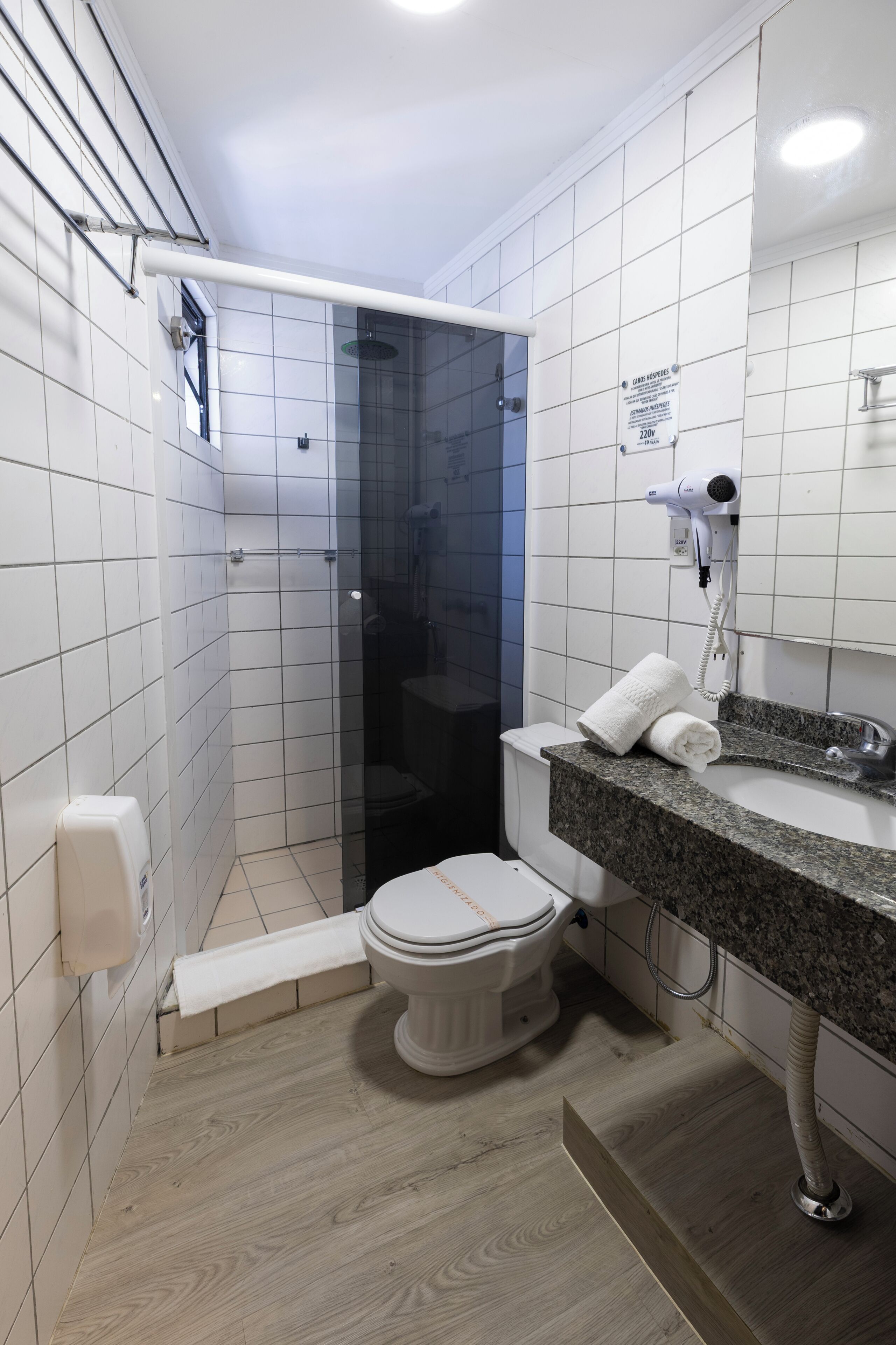Un baño con ducha, inodoro y lavabo.