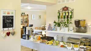 Montaje tipo bufé con diversos alimentos, una estación de café y un enfriador de vino instalado en la pared.