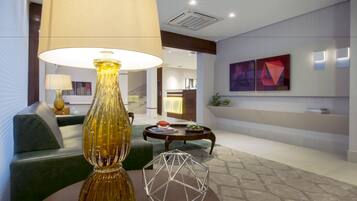 A modern living room with a large lamp, a geometric glass sculpture, and a sofa.