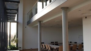 Un vaste espace intérieur doté d’un haut plafond, de grandes fenêtres et d’une mezzanine.
