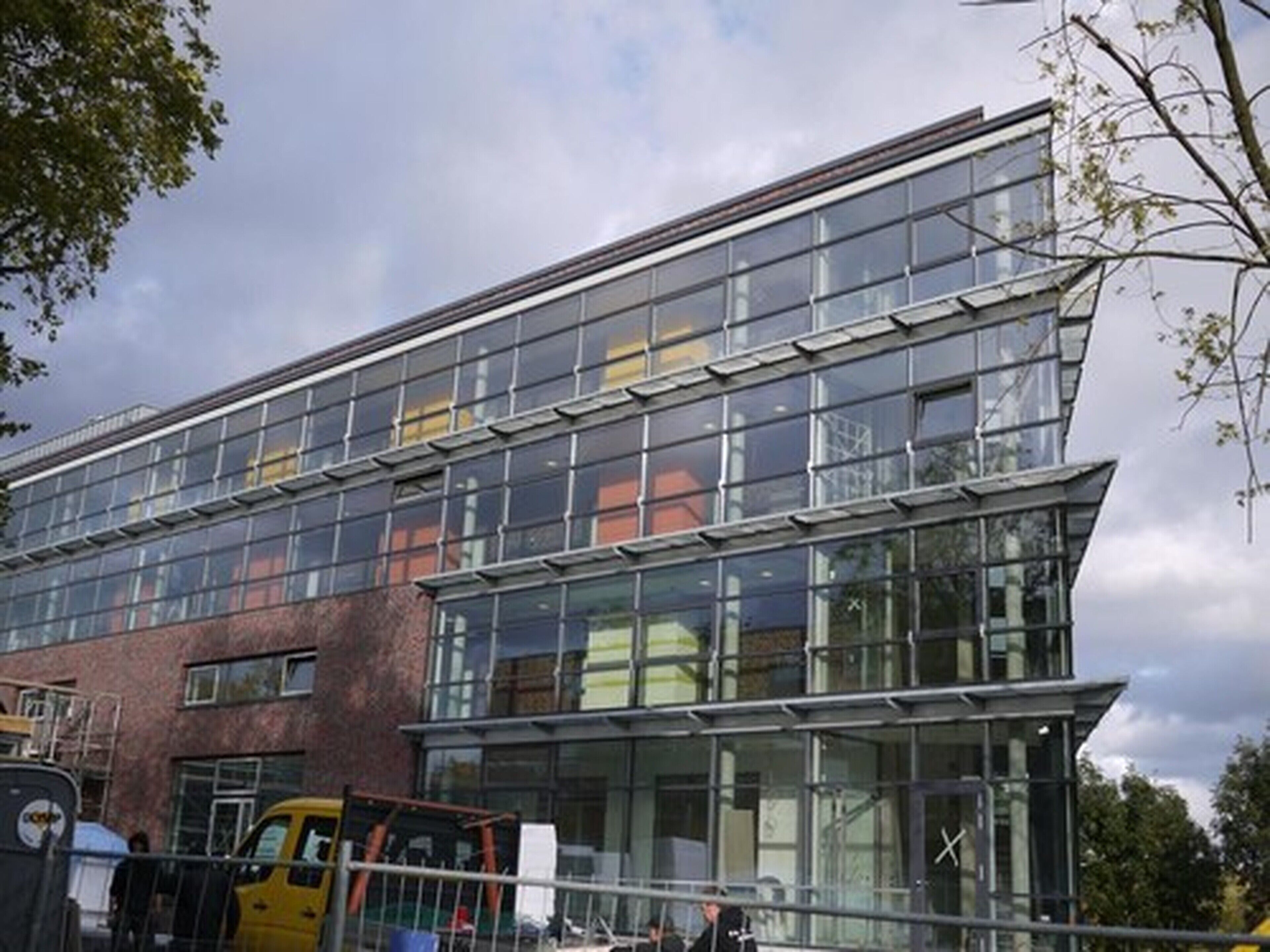 A modern building with large glass windows and a brick facade.