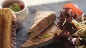 A meal consisting of a toasted bread slice, a meatloaf cut, and a salad with mixed greens and shredded carrots.