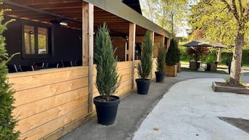 Un espace extérieur abrité, doté de murs en bois et agrémenté de plantes en pot.