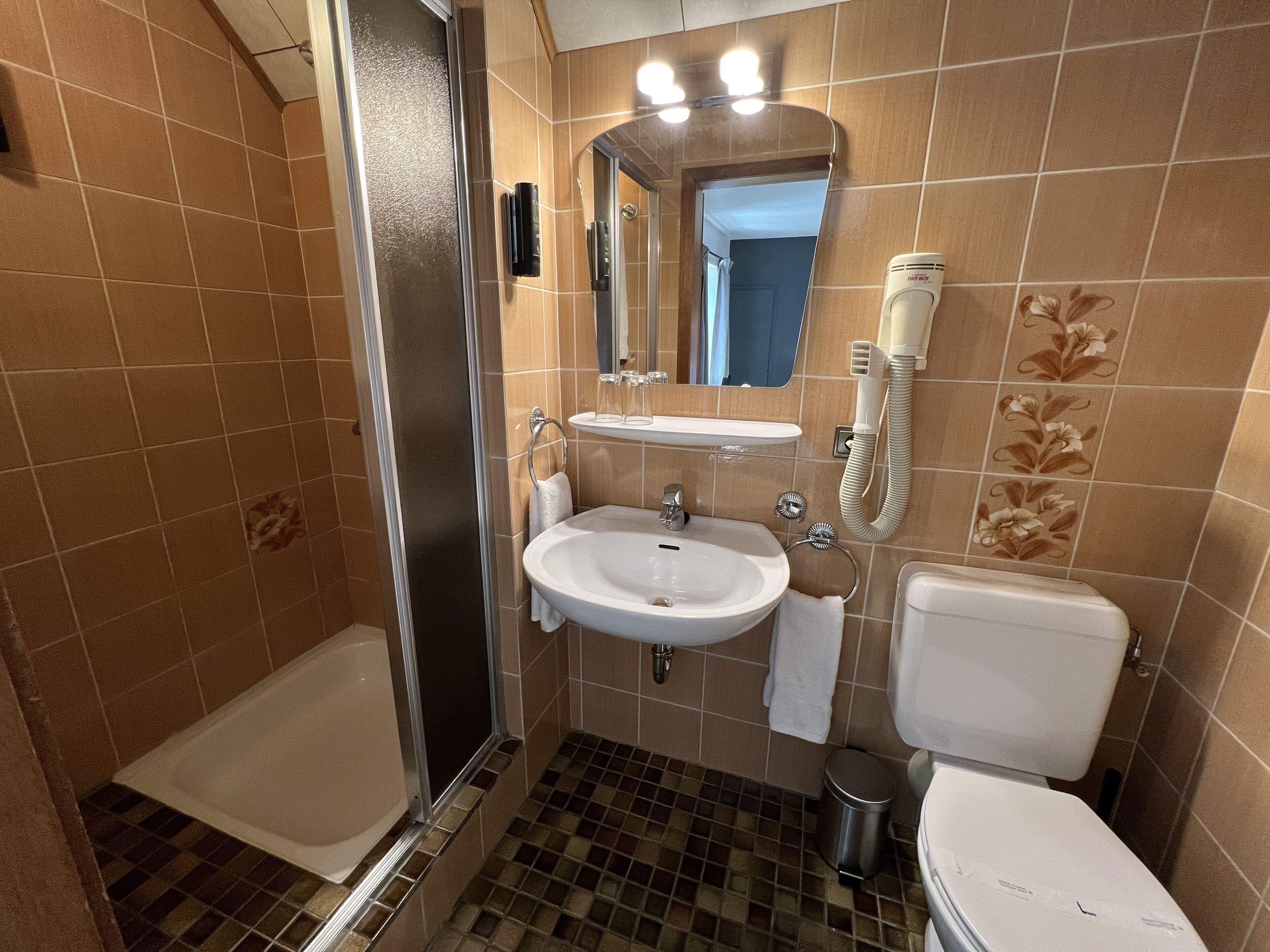 Un baño con ducha, lavabo e inodoro.