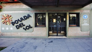 A building with a sign reading "POADA DEL SOL" and a black gate.