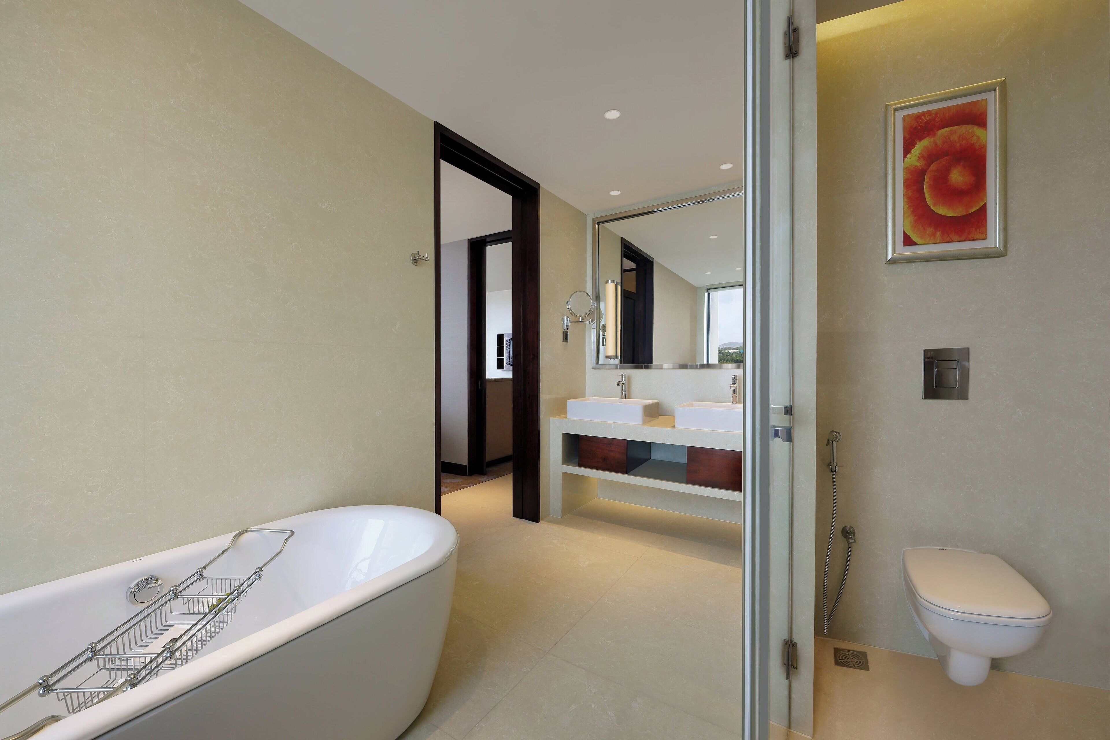 Un baño moderno con una bañera independiente, un inodoro y un tocador con espejo.