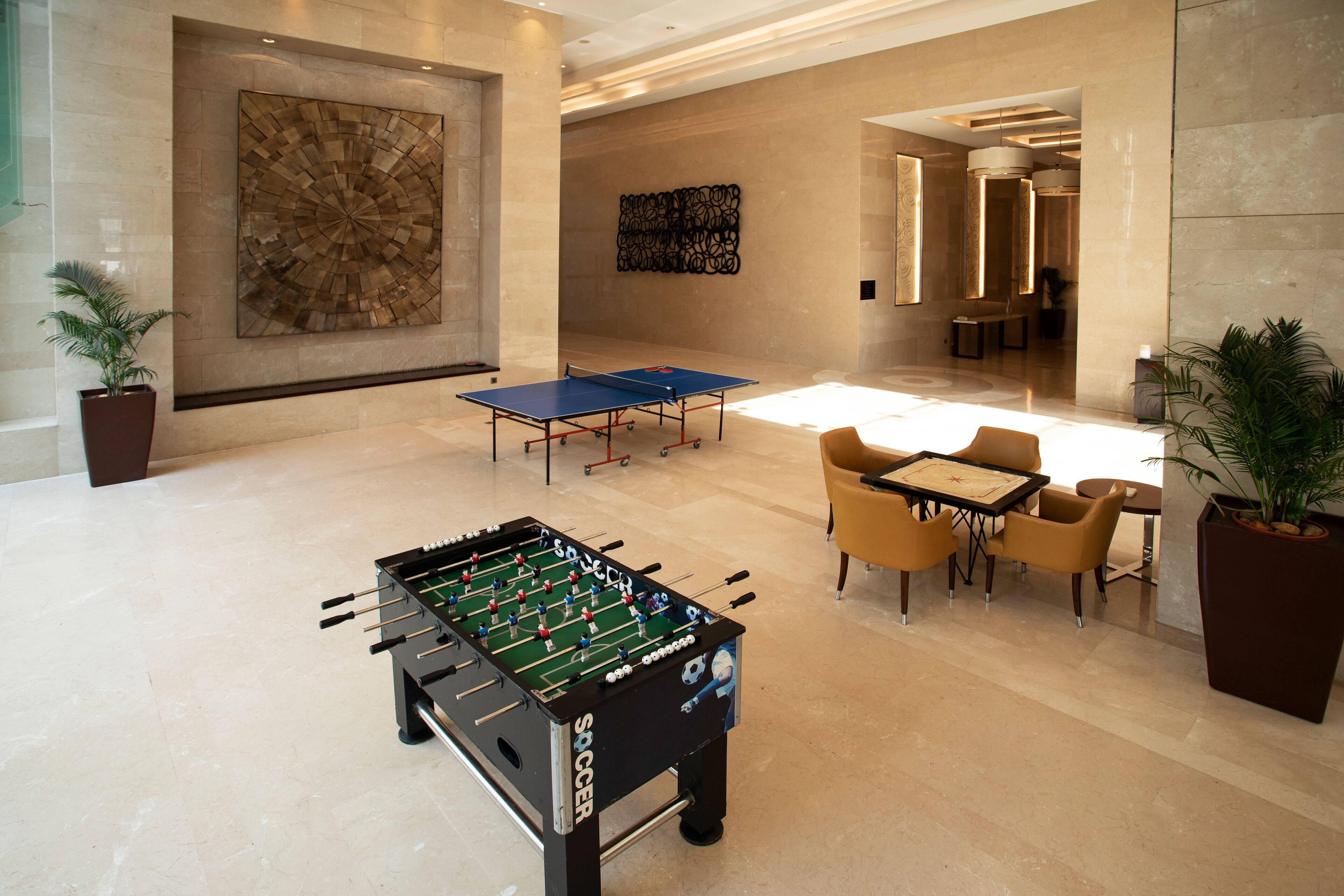 A spacious lobby with a foosball table, comfortable seating, and modern art on the walls.