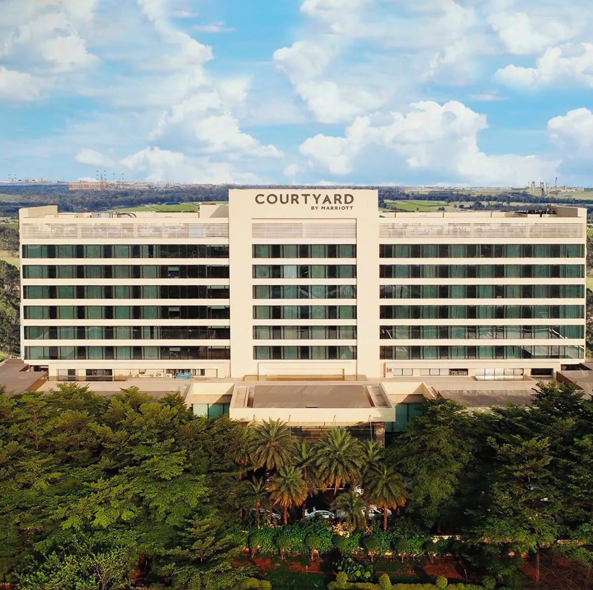 A multi-story building with a sign reading 'COURTYARD BY MARRIOTT' indicating a Marriott hotel.