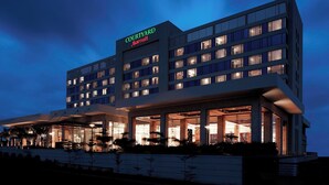 A Courtyard Marriott hotel with a modern design, featuring multiple floors and a well-lit entrance. - Courtyard by Marriott Pune Chakan (Rajgurunagar)