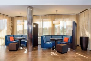 Relax in the stylish lobby with a seating area, cylindrical pillar, and planter.