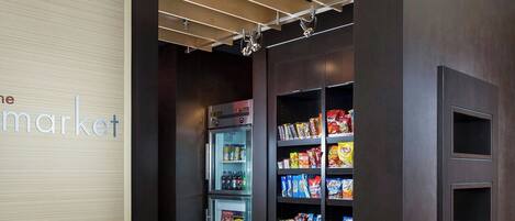 Ein Korridor mit einem Getränkeautomaten, der mit Snacks gefüllt ist, einer Holzwand mit einem Schild und einem gefliesten Boden.