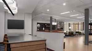 A modern hotel lobby with a reception desk, seating area, and a stone fireplace.