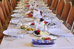 A long dining table set with plates, glasses, and various food items.