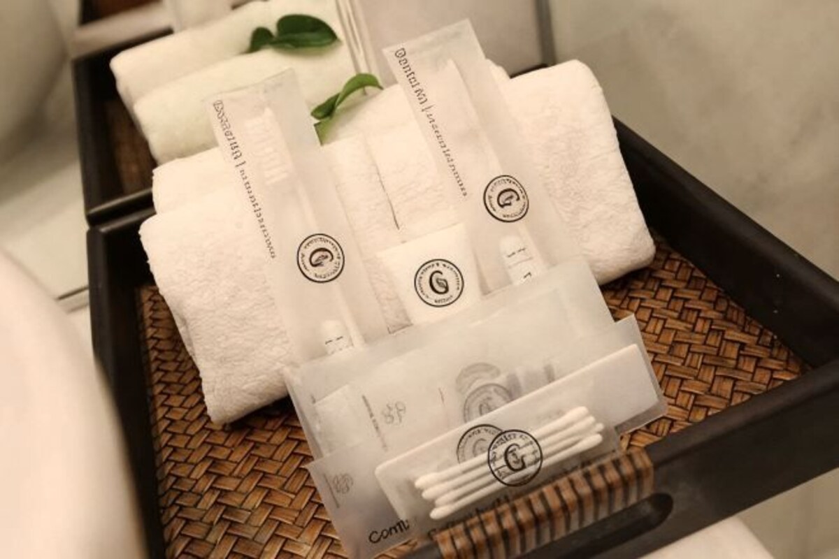 A tray with white towels and a clear plastic container with cotton swabs.