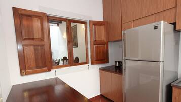 Eine Küche mit Holzausbau, einem Edelstahlkühlschrank und einem Holztisch.