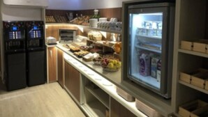 Eine moderne Küche mit Einbaukühlschrank, einer Kaffeemaschine und verschiedenen Lebensmitteln, die auf der Arbeitsplatte präsentiert werden.