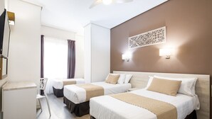 Ein Hotelzimmer mit zwei Betten, einem Schreibtisch und einem Stuhl.
