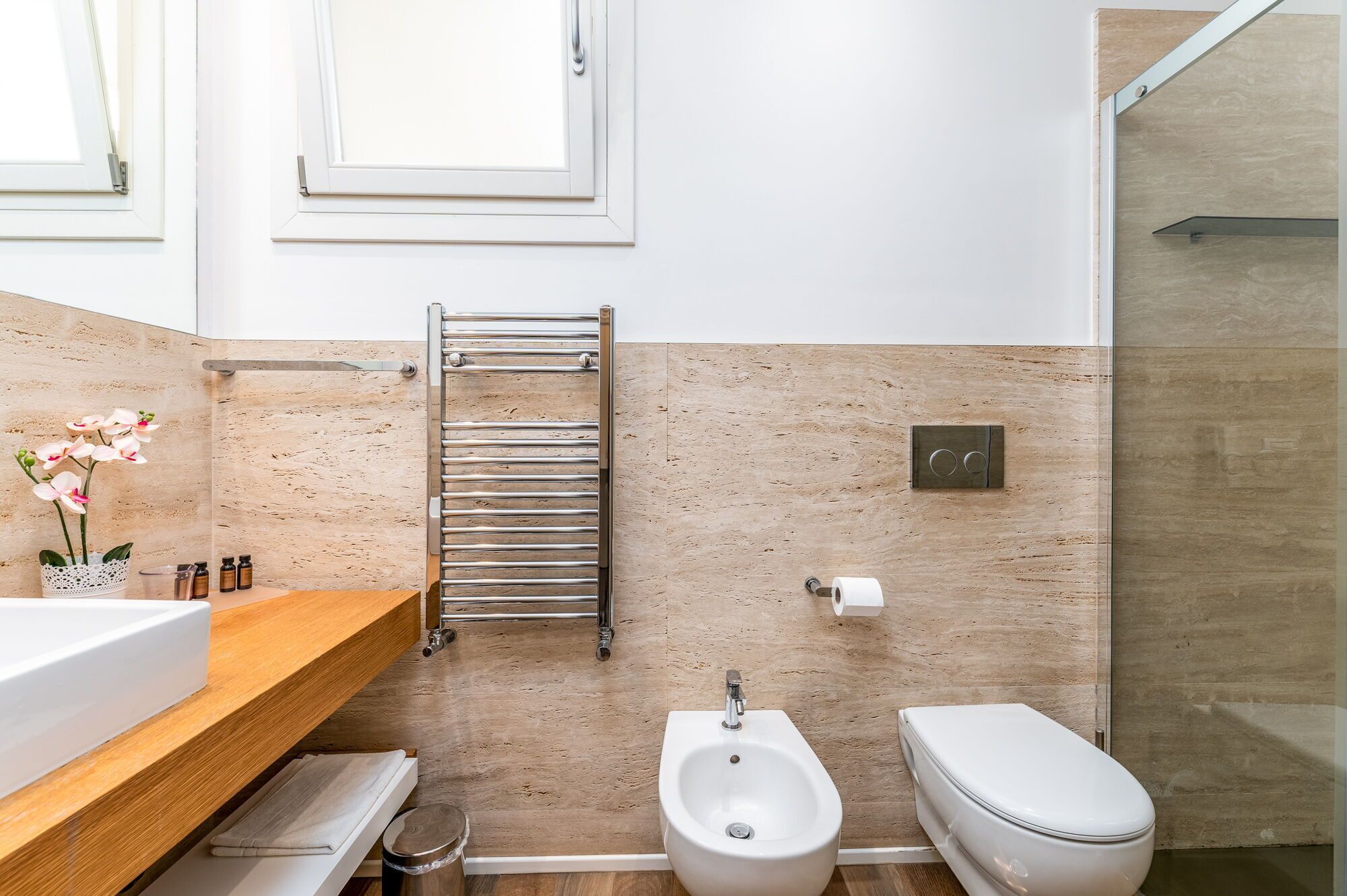 Un baño moderno con bidé, inodoro y un perchero para toallas.