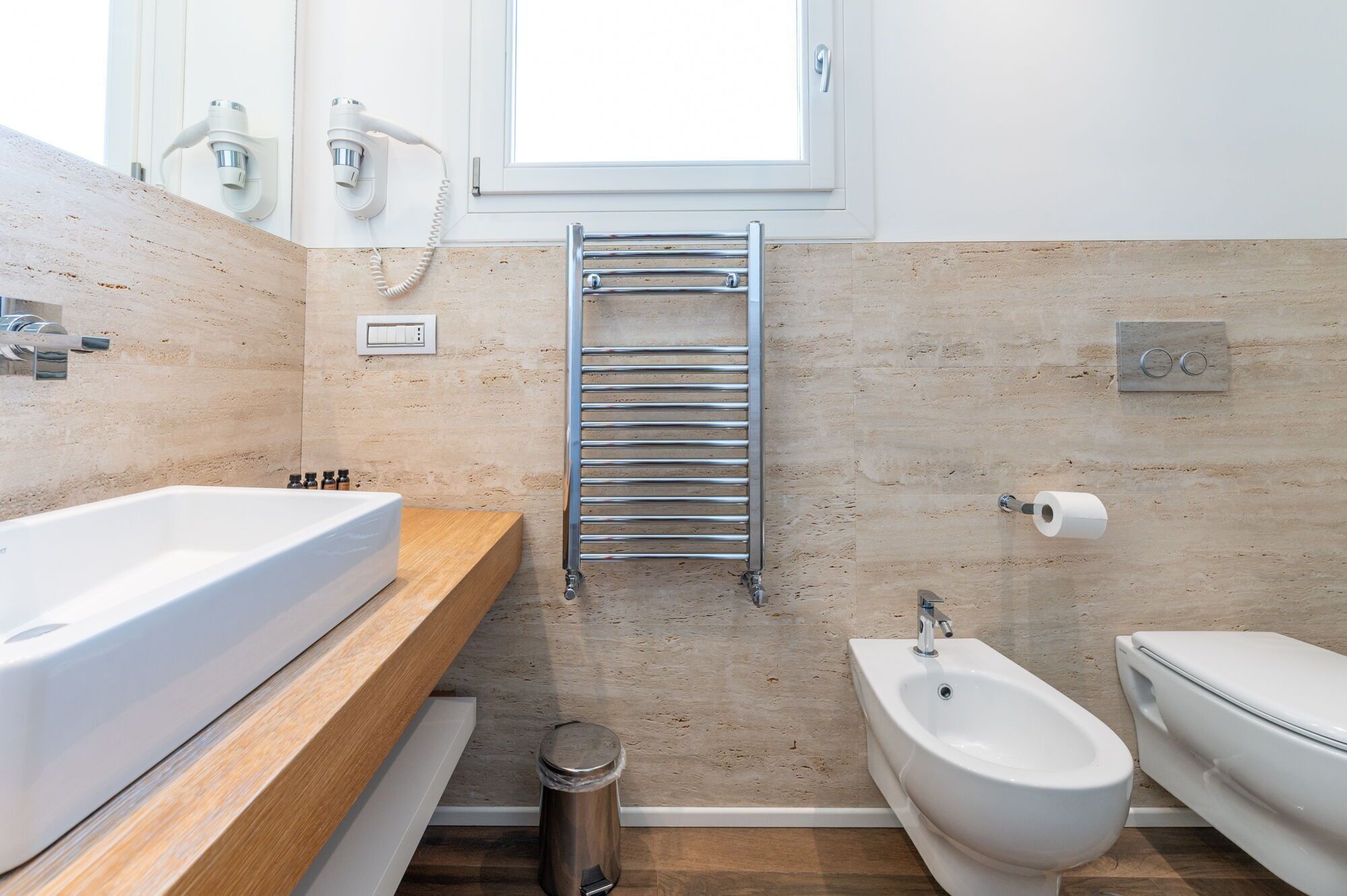 Un baño moderno con una bañera grande, un bidé y un perchero para toallas.