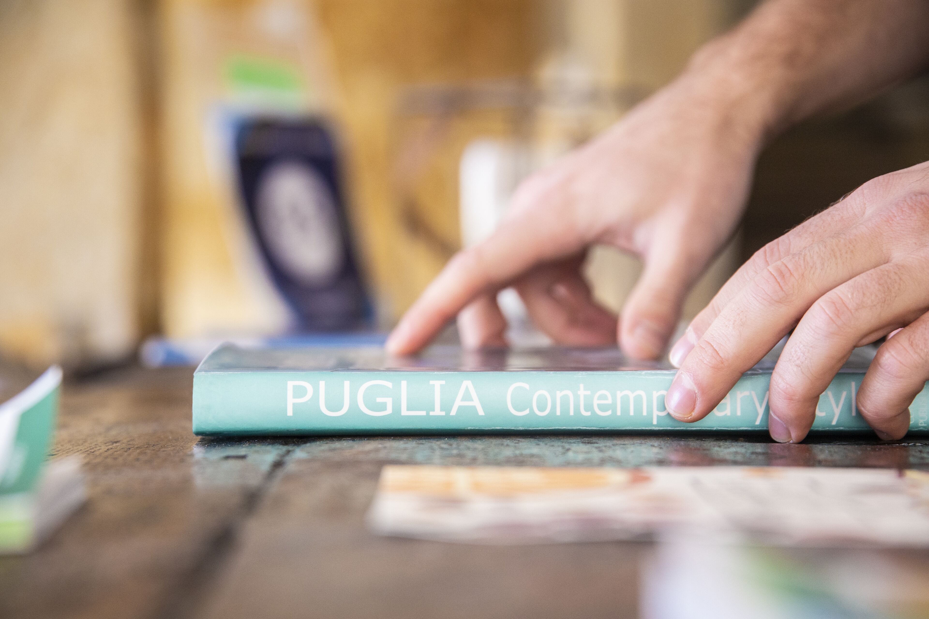 A book titled "Puglia Contemporary Style" on a wooden surface.