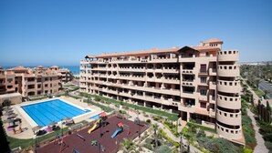 Um hotel com vários andares, piscina, área de recreação ao ar livre e varandas.