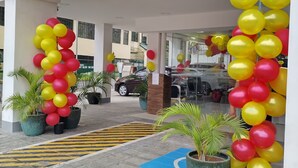 A hotel entrance with yellow signage reading "1718 DIAN PLACE" and a yellow and red balloon arch. - Dian SUITES 1 (Makati)