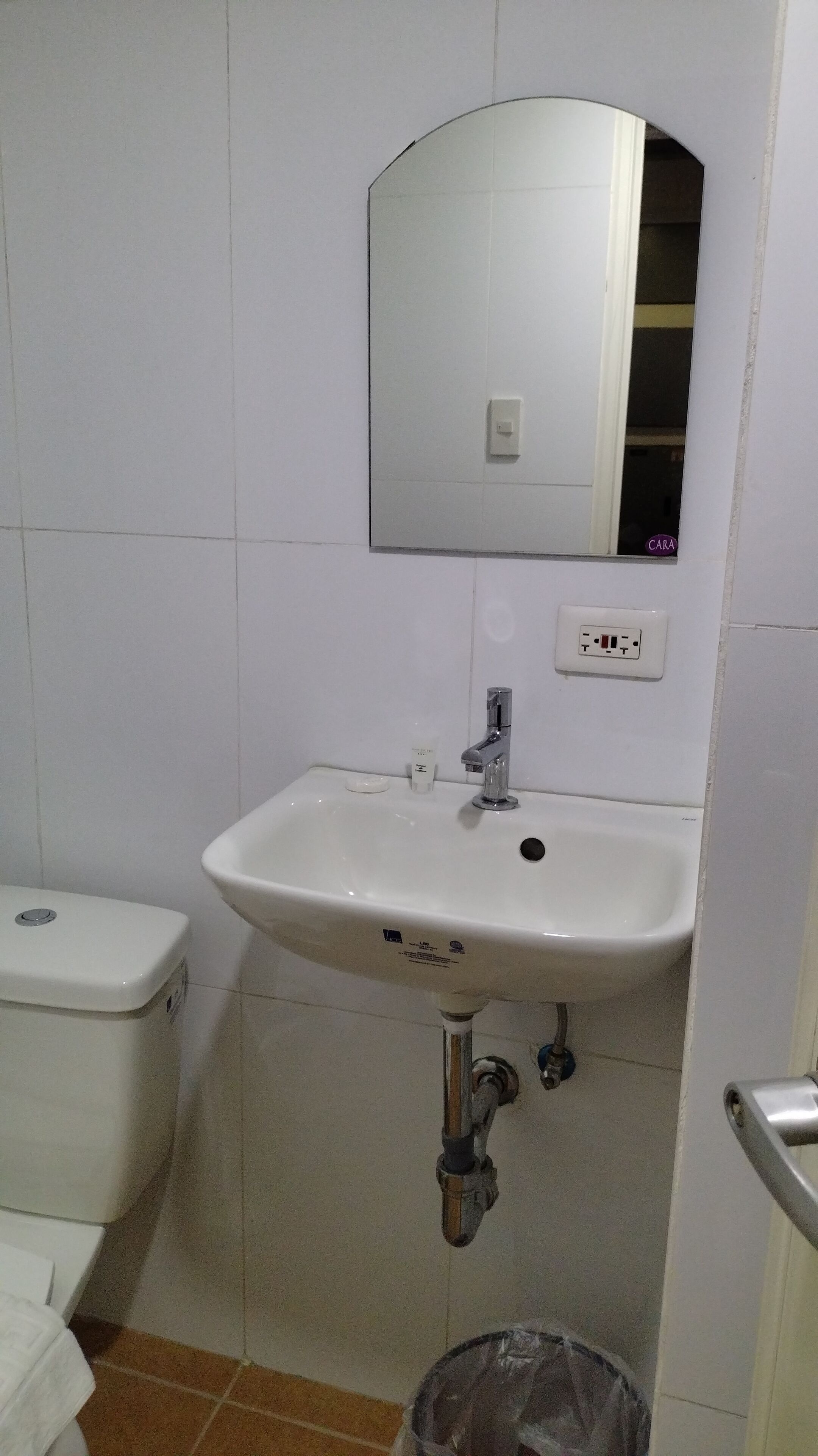 A bathroom with a white sink, a mirror, and a toilet.
