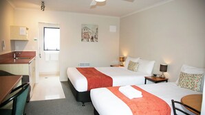 A hotel room with two beds, a desk, and a kitchenette. - Bella Vista Motel Hamilton (Hamilton)