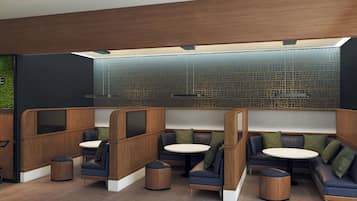 Un espace de détente moderne, doté de différents types de sièges, d’un mur décoratif et d’un plafond en bois.