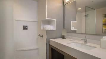 A modern bathroom with a double sink, a mirror, and a towel rack.