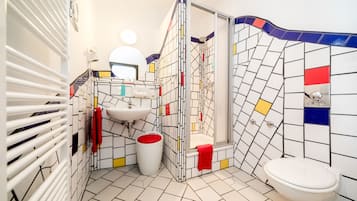 Ein Badezimmer mit einem weißen Waschbecken, einer Toilette und einer Dusche mit Glastür.