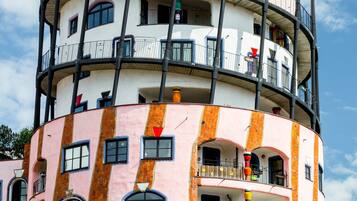 A multi-story building with balconies, large windows, and a unique architectural design.