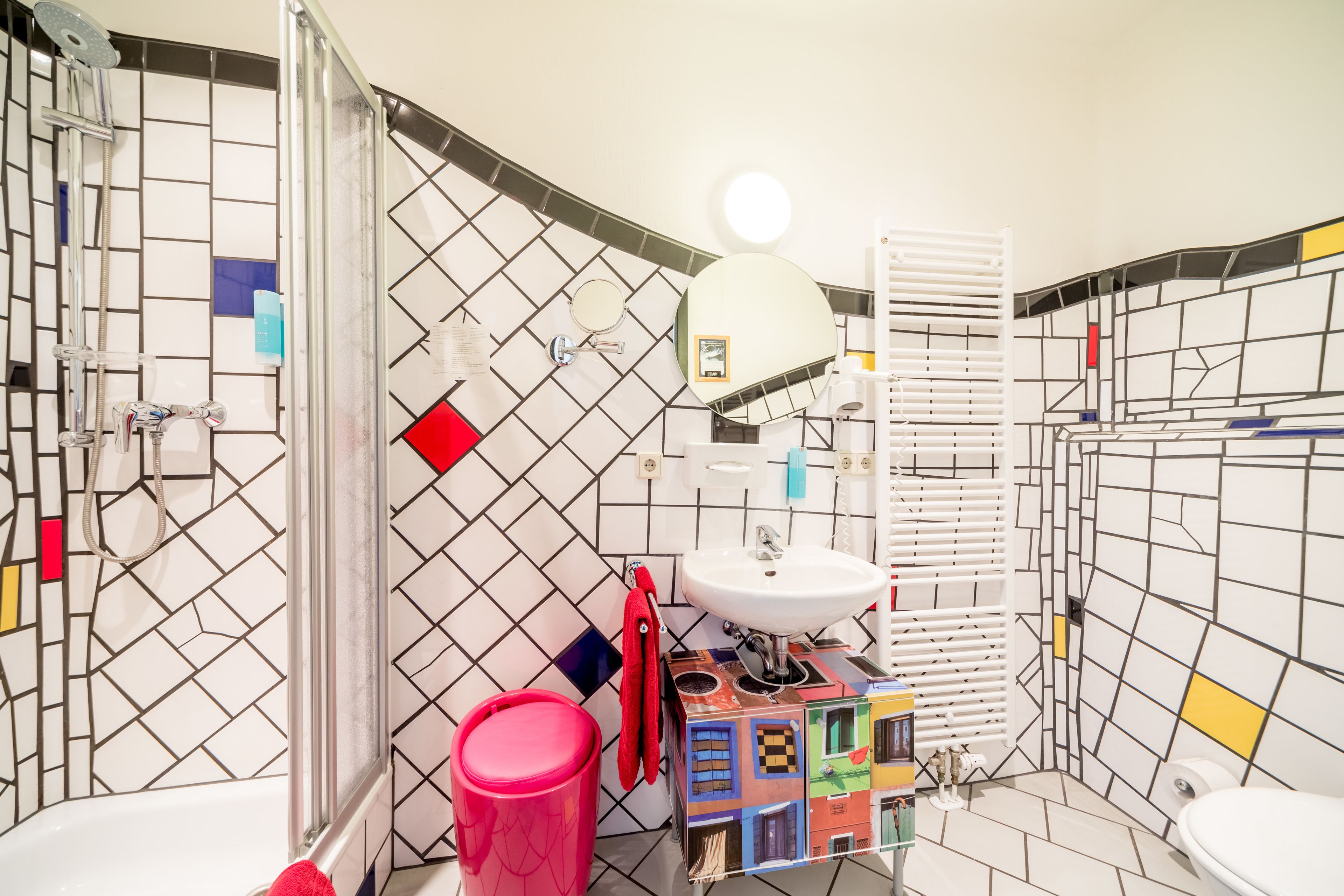 A bathroom with a white sink, a mirror, a toilet, and a shower.