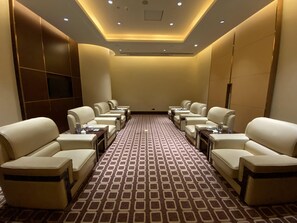 A hotel room with a long row of leather armchairs, a patterned carpet, and a recessed ceiling light. - Crowne Plaza Shaoxing by IHG (Shaoxing)
