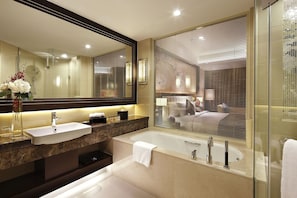 Relax in a spacious bathroom with a bathtub and sleek vanity.